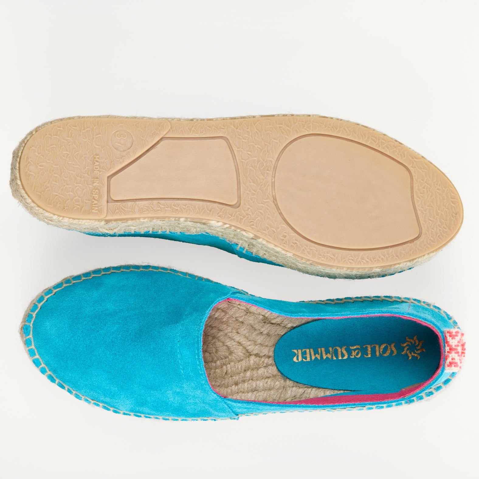 A pair of women's turquoise suede loafer espadrilles. One of the footwear is turned over to show the underneath. It has a full rubber covering and the other shoe shows the inner, unlined jute insole and the Sole of Summer logo.