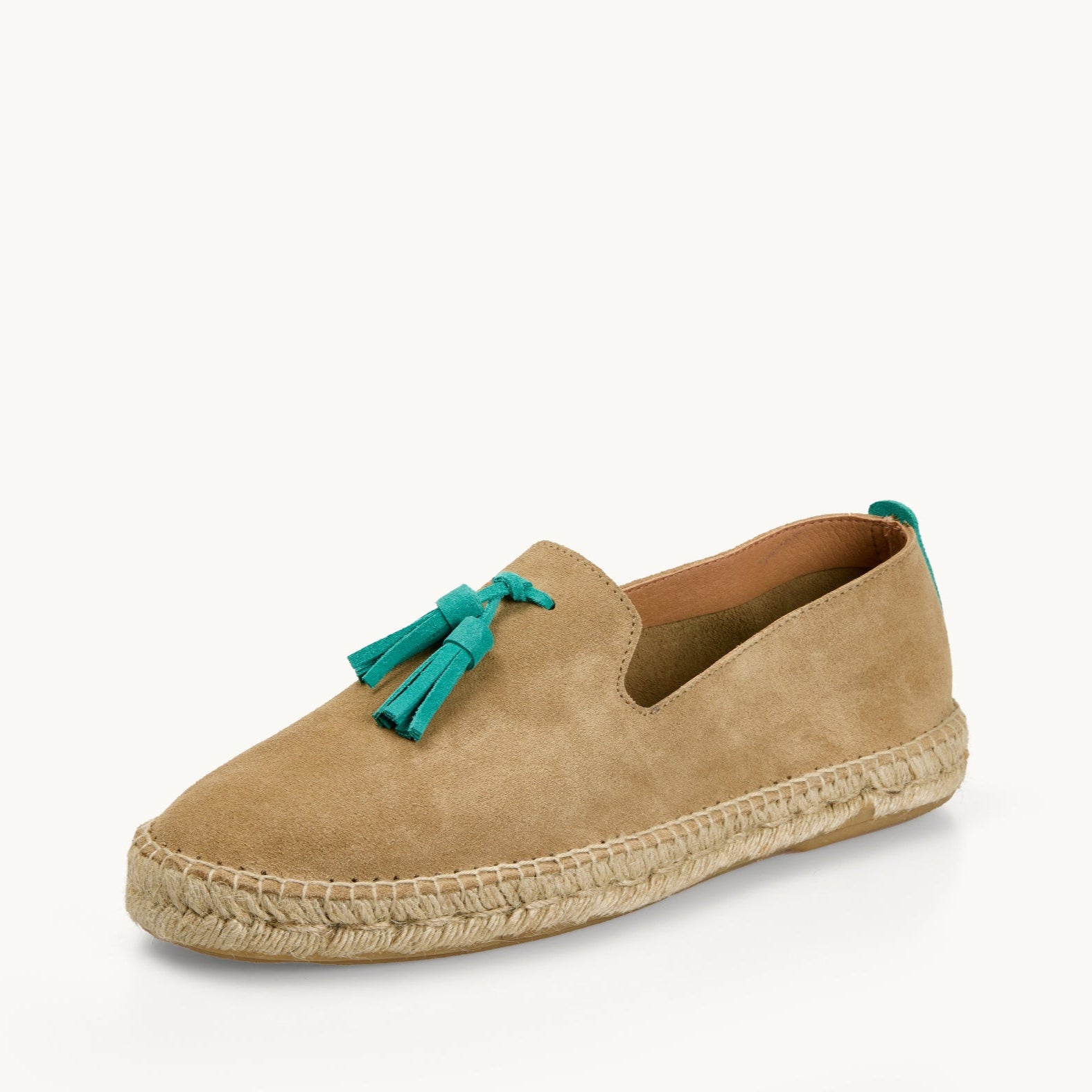 One men's light tan suede loafer. Jute sole. Neck opening of the espadrille has a narrow tan edged inside the shoe. Two turquoise suede tassels on the front.