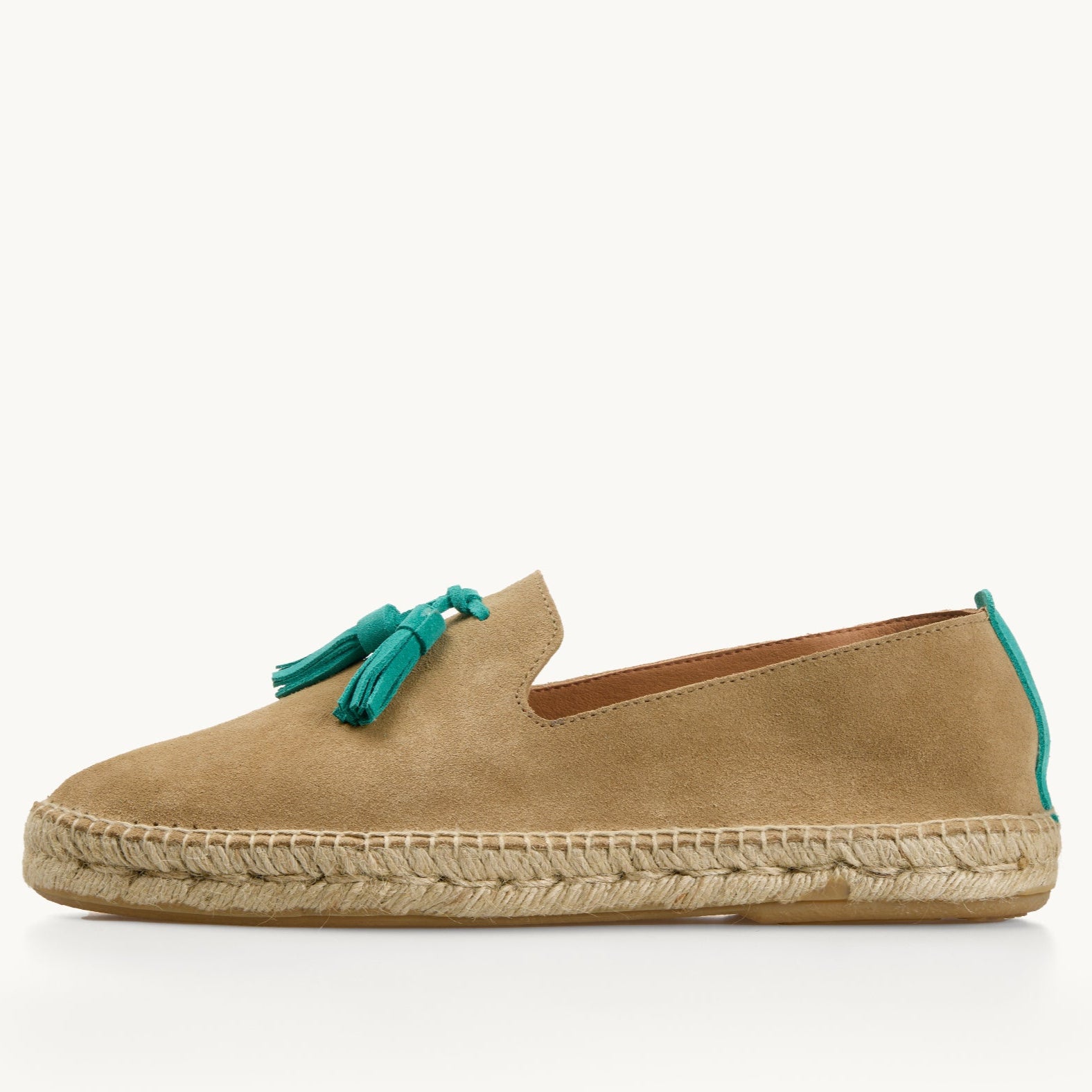 One men's light tan suede loafer. Jute sole. Neck opening of the espadrille has a narrow tan edged inside the shoe. Two turquoise suede tassels on the front and a stripe of turquoise suede up the heel.