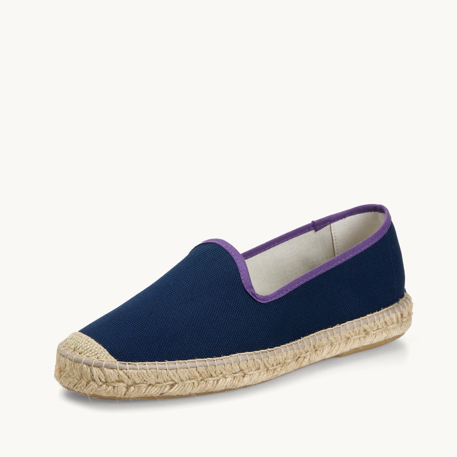 One men's navy blue cotton canvas loafer. Jute sole and detail on the toe. Neck opening of the espadrille has a narrow ribbon edged in dark purple. Inside of the footwear is white.