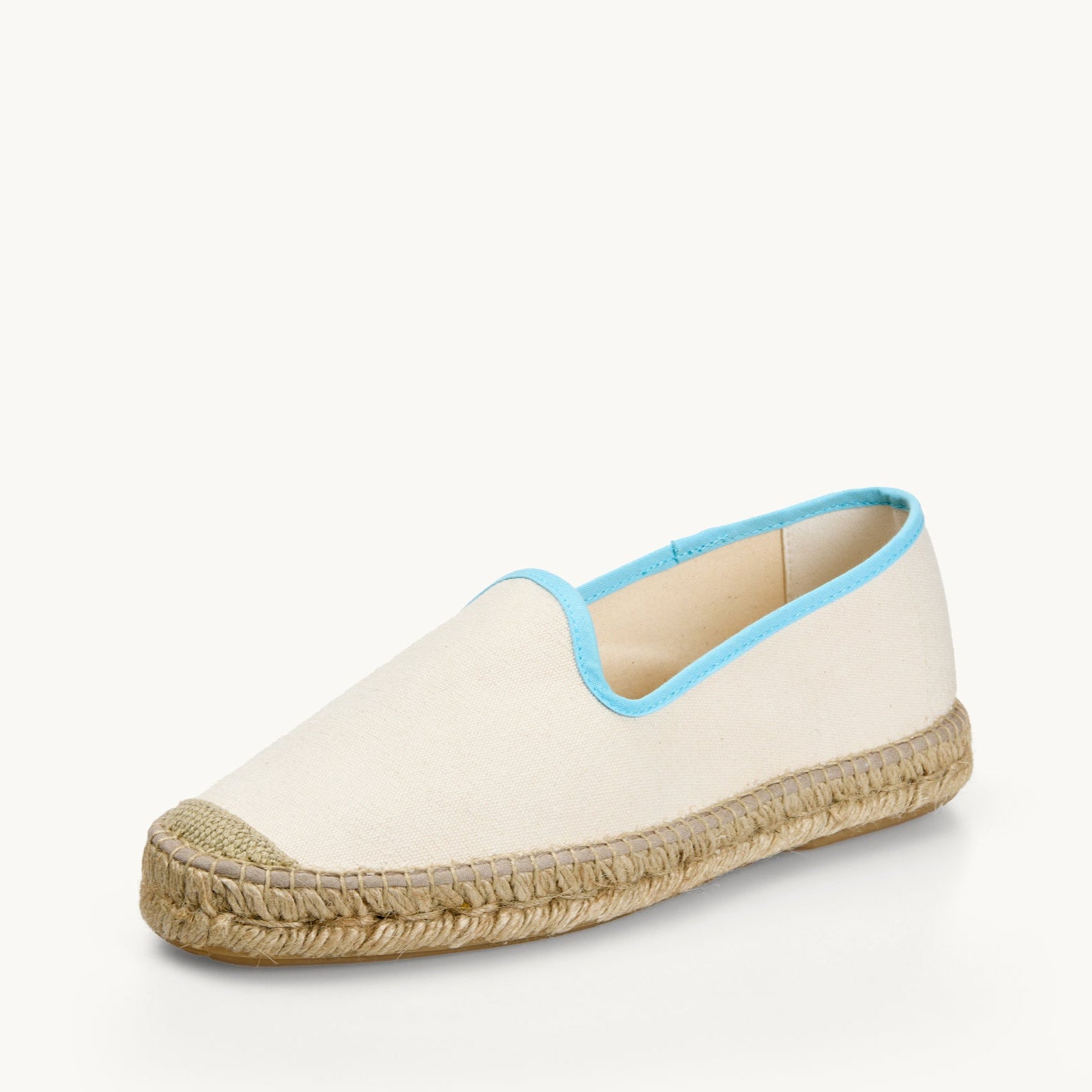 One men's white cotton canvas loafer. Jute sole and detail on the toe. Neck opening of the espadrille has a narrow ribbon edged in light blue. Inside of the footwear is white.