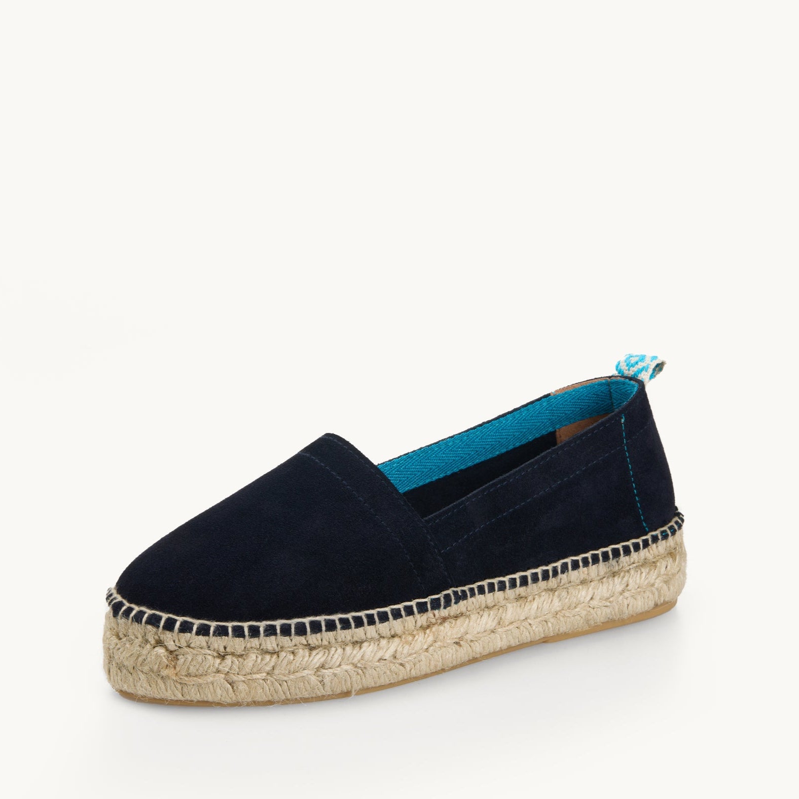 Navy blue suede platform loafer edged with Turquoise  trim inside the neck of the shoe and a turquoise and white diamond pattern ribbon up the heel. The traditional espadrille is stitched to the jute sole.