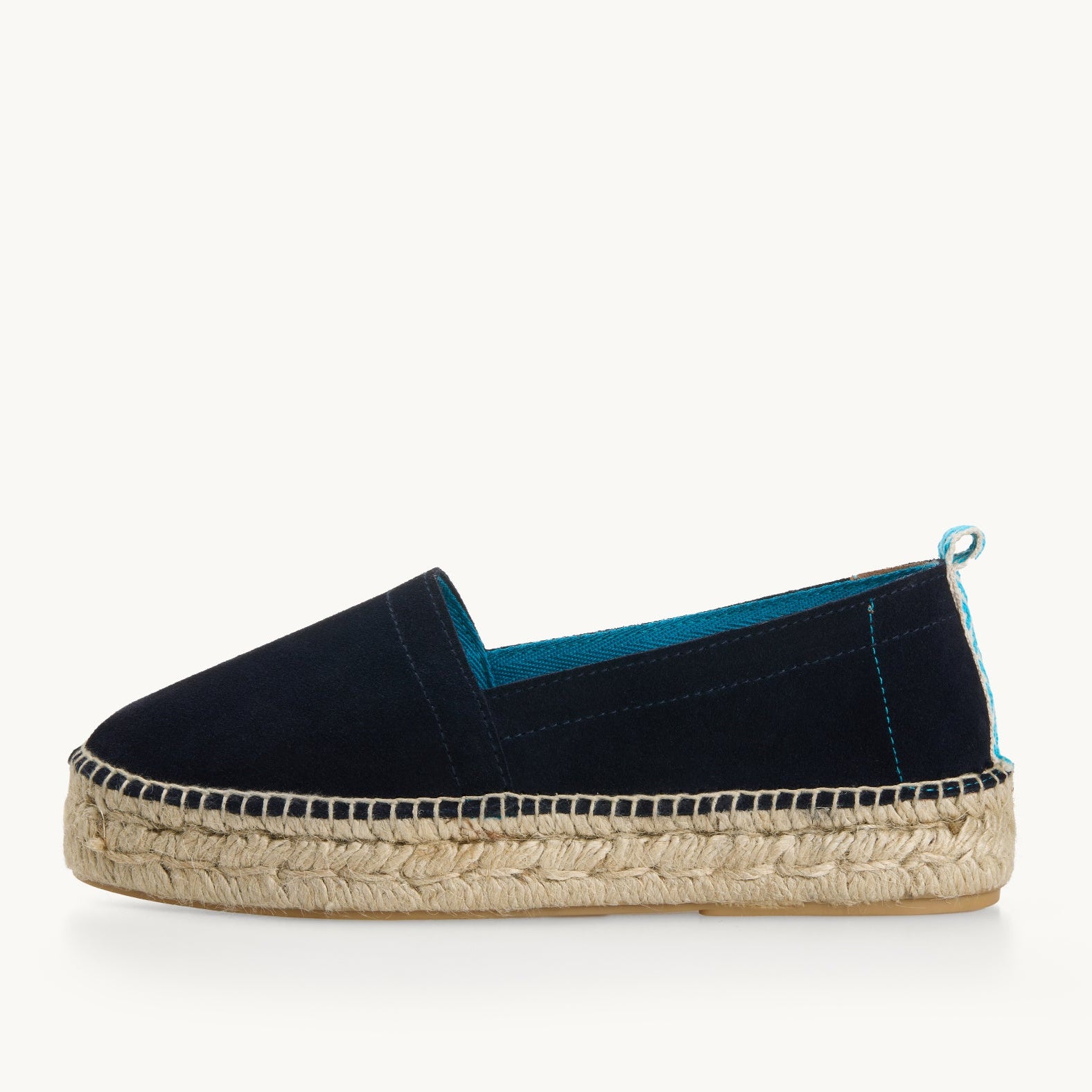 Navy blue suede platform loafer edged with Turquoise  trim inside the neck of the shoe and a turquoise and white diamond pattern ribbon up the heel. The traditional espadrille is stitched to the jute sole.